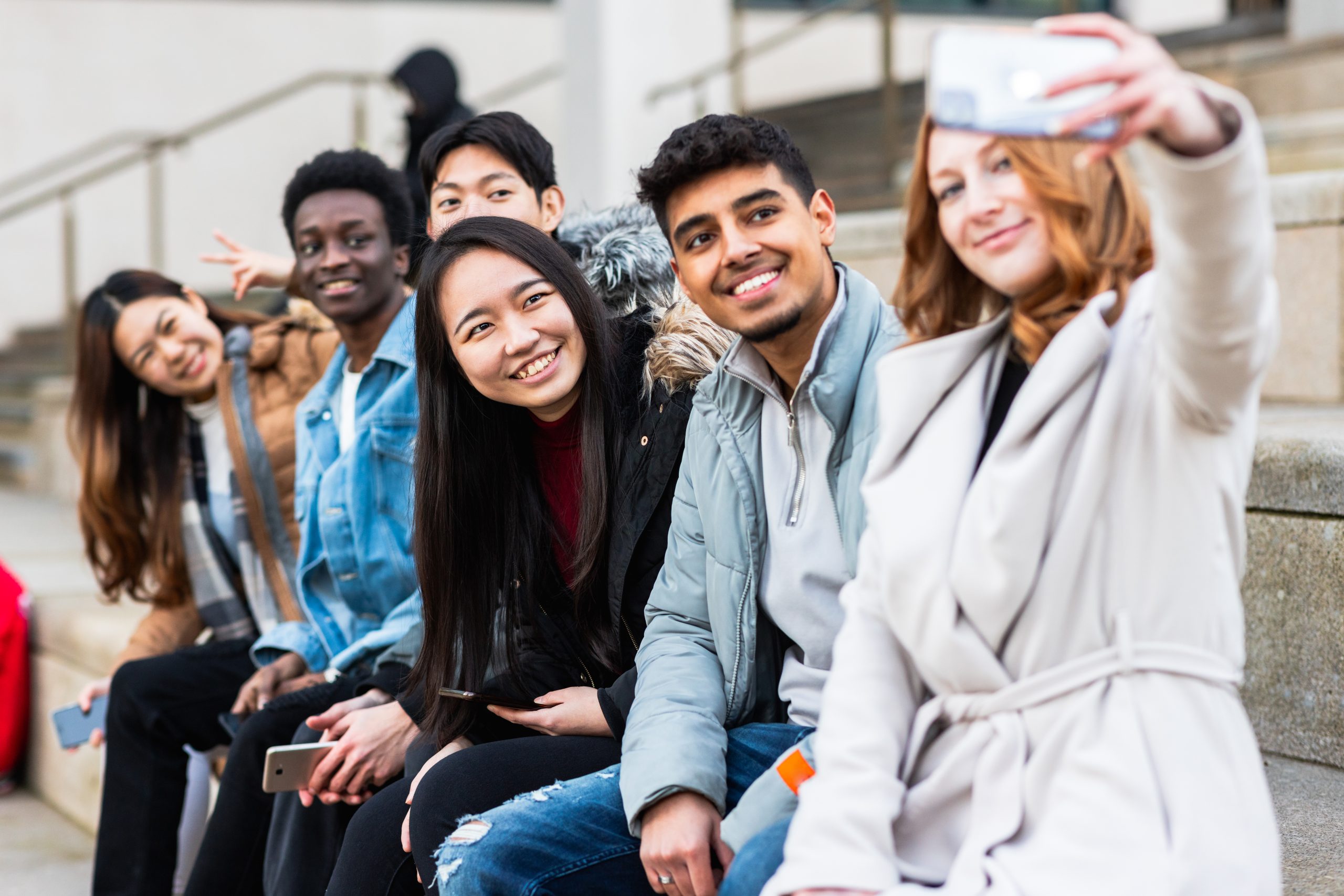 Multiracial people taking a selfie together and making funny fac